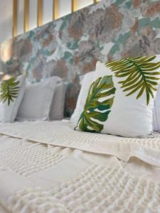 a bed with white sheets and a pillow with leaves at Eora Studios in Laganas