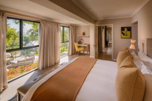 een slaapkamer met een bed en een groot raam bij Leeu Estates in Franschhoek +137 foto's