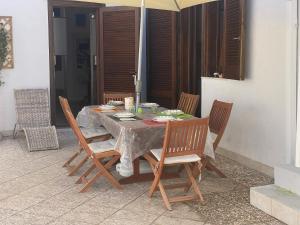 a table with chairs and an umbrella on a patio at Casa Rosario - Villetta Indipendente in Felline