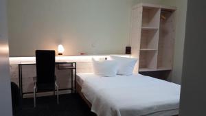 1 dormitorio con 1 cama con escritorio y silla en Die Kapelle Bed & Breakfast en Bad Liebenstein