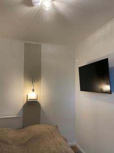 een slaapkamer met een bed en een flatscreen-tv aan de muur bij Magnus & Morgentau in Göhren
