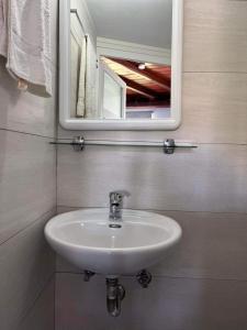 ein weißes Waschbecken im Bad mit Spiegel in der Unterkunft Mykonian beauty(beach spot) in Platis Gialos