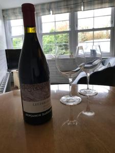 a bottle of wine and two wine glasses on a table at The Bolt Hole - Looe. in Looe