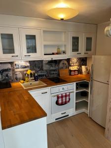 a kitchen with white cabinets and a white refrigerator at Karja Apartment with sauna in Haapsalu