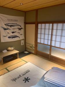 Cette chambre comprend un lit et une affiche murale. dans l'établissement 海豚自由 イルカフリー Free dolphin, à Shimoda