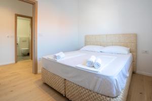 a bedroom with a large bed with towels on it at Luxury Landing in Cres