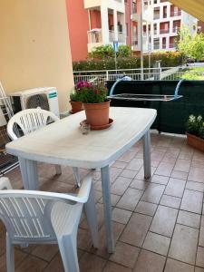 a white table and chairs on a patio with flowers at Appartamento Verona in Verona