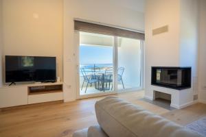a living room with a couch and a television at Luxury Landing in Cres