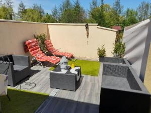 a backyard with a patio with chairs and a tv at Gite Ray . in Brévonnes