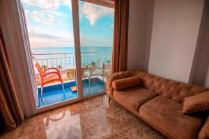 a living room with a couch and a large window at Kristal Beach Hotel in Antalya