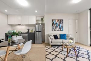 cocina y sala de estar con sofá y mesa en WOW Apartment on Collins en Melbourne