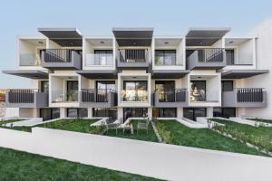 an apartment building with balconies and a yard at Calm Chaos studio 1 in Kallithea Halkidikis