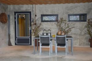 einen Tisch und Stühle in einem Zimmer mit Tür in der Unterkunft Vakantiewoning Kalverliefde in Zeerijp