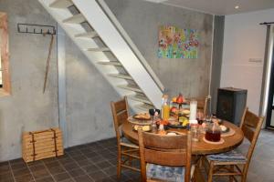 een eetkamer met een tafel en een trap bij Vakantiewoning Kalverliefde in Zeerijp