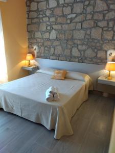 a bedroom with a bed with a stone wall at Lungomare Bed rooms in Santa Maria Navarrese