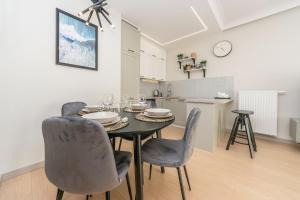 comedor con mesa y sillas y cocina en Hello Apartments Letnica with sea view and private parking en Gdansk