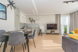 comedor y sala de estar con mesa y sillas en Hello Apartments Letnica with sea view and private parking en Gdansk
