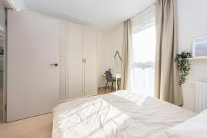 Un dormitorio blanco con una cama grande y una ventana en Hello Apartments Letnica with sea view and private parking en Gdansk