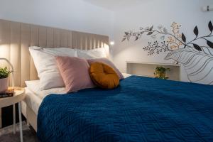 1 dormitorio con 1 cama con edredón y almohadas azules en Home Sweet Home, en Cracovia