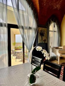 Private guest house in five stars resort في رأس الخيمة: غرفة معيشة مع طاولة وبيانو