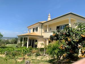 uma casa com uma laranjeira em frente em Villa Tranberg Suites em Ferreiras