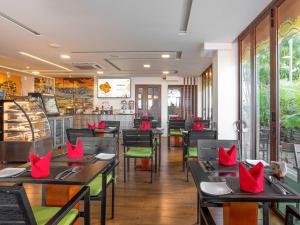 a restaurant with tables and chairs with red pillows on them at h78 in Hulhumale