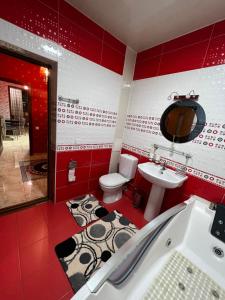 a red bathroom with a toilet and a sink at Apartment Tashkent , апартаменты Ташкент in Tashkent +10 photos