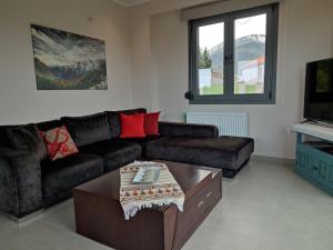 uma sala de estar com um sofá e uma mesa de centro em Villa Lakki's Ori em Lákkoi