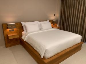 a bedroom with a large bed with white sheets and pillows at Sandat Living in Canggu