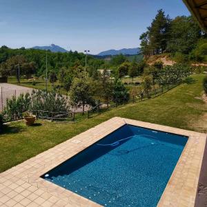 a large blue swimming pool in a yard at Mas Cal Sastre in Sant Hilari Sacalm