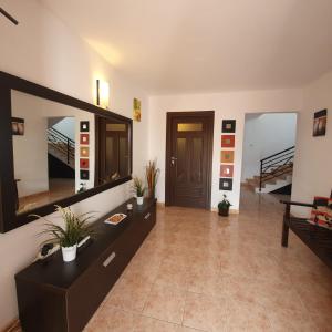 a living room with a large mirror and a staircase at VILA TAMI in Costinesti