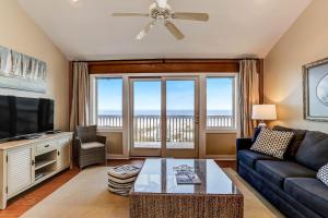 a living room with a couch and a tv at Oceanfront Pet Friendly Unit in Fernandina Beach