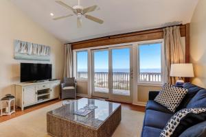 sala de estar con sofá azul y TV en Oceanfront Pet Friendly Unit, en Fernandina Beach