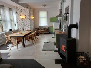 eine Küche und ein Esszimmer mit einem Herd im Zimmer in der Unterkunft Die Kapelle Bed & Breakfast in Bad Liebenstein