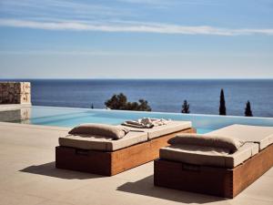 2 camas en un patio junto a una piscina en The Sall Villa en Agios Nikolaos