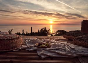 a table with a bowl of fruit and a sunset at The Sall Villa in Agios Nikolaos