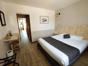 a bedroom with a large bed and a table at Logis Le Nid du Pont de Gau in Saintes-Maries-de-la-Mer