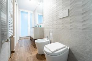 Baño blanco con aseo y lavamanos en [Catania Center] Modern Apartment, en Catania