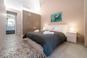 1 dormitorio con 1 cama grande y 2 toallas en [Catania Center] Modern Apartment, en Catania