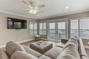 a living room with a couch and a ceiling fan at Beach House w Backyard in Fernandina Beach