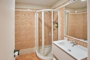 uma casa de banho com um chuveiro e um lavatório. em Apartamentos Los Arroyos em Ponferrada