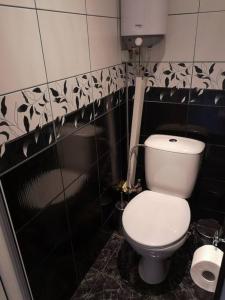 a bathroom with a toilet in a black and white wall at Apartment Serkyovi in Pomorie