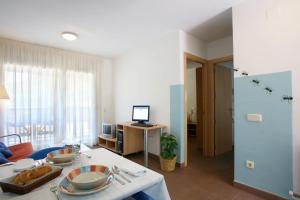 a living room with a table and a room with a television at La Faiada in El Pont de Suert