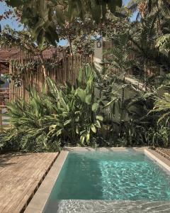 a swimming pool in the middle of a garden at Frangipani El Nido in El Nido