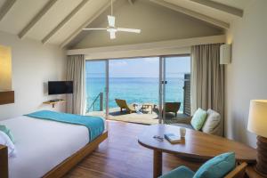 a bedroom with a bed and a view of the ocean at Centara Ras Fushi Resort & Spa Maldives - 50 percent discount on transfers for min 4 nights stay and more, valid for reservations between 11th Feb till 22 Dec 2025 in North Male Atoll