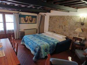 a bedroom with a bed in a room with a table at LE PIANACCE - Appartamento per vacanze in Castiglione di Garfagnana