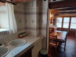 baño con 2 lavabos, mesa y cocina en LE PIANACCE - Appartamento per vacanze, en Castiglione di Garfagnana