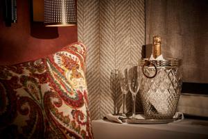 a table with a bottle of perfume and a wine glass at The Tophams Hotel in London