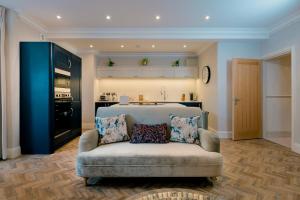 a living room with a couch and a kitchen at Derwent House Apartments in Scarborough