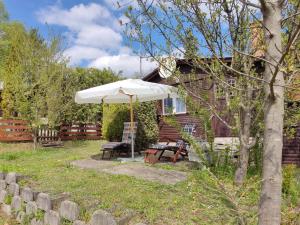 a patio with an umbrella and a table and chairs at Ferienhaus im Donauknie für Familien & Hunde in Leányfalu
